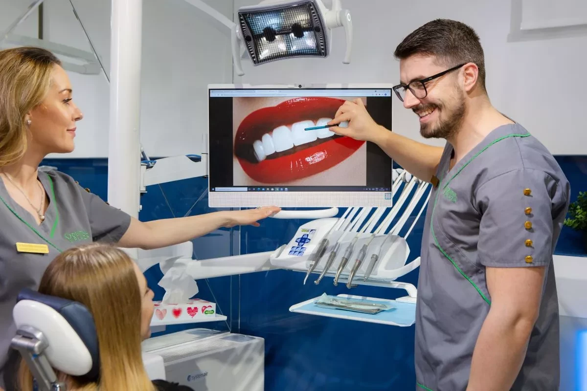 stomatolog pokazuje na snimak zuba