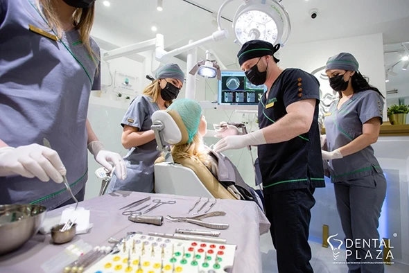 A patient with a dentist and nurses in the process of installing an implant.